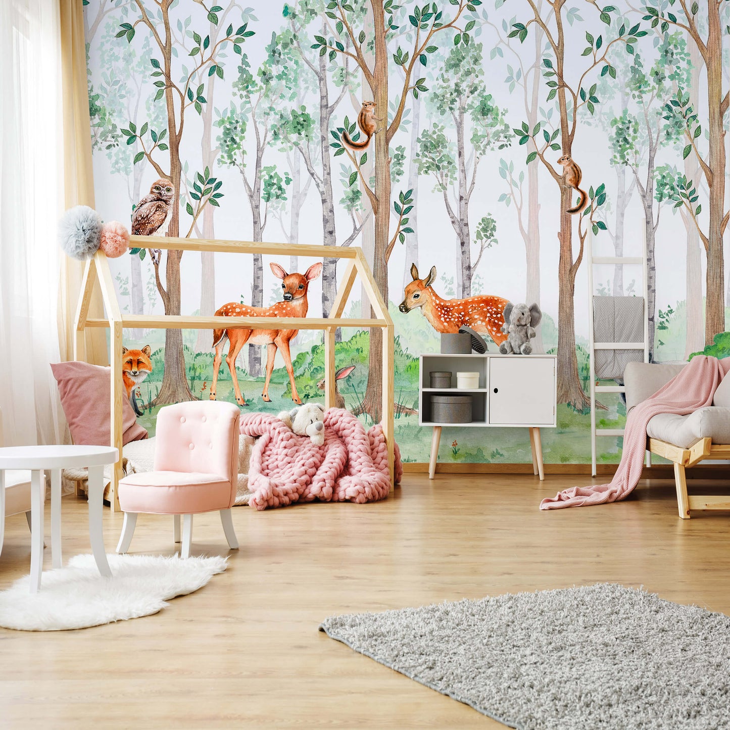 A nursery room with wallpaper featuring various forest animals, trees, and a playful owl design.