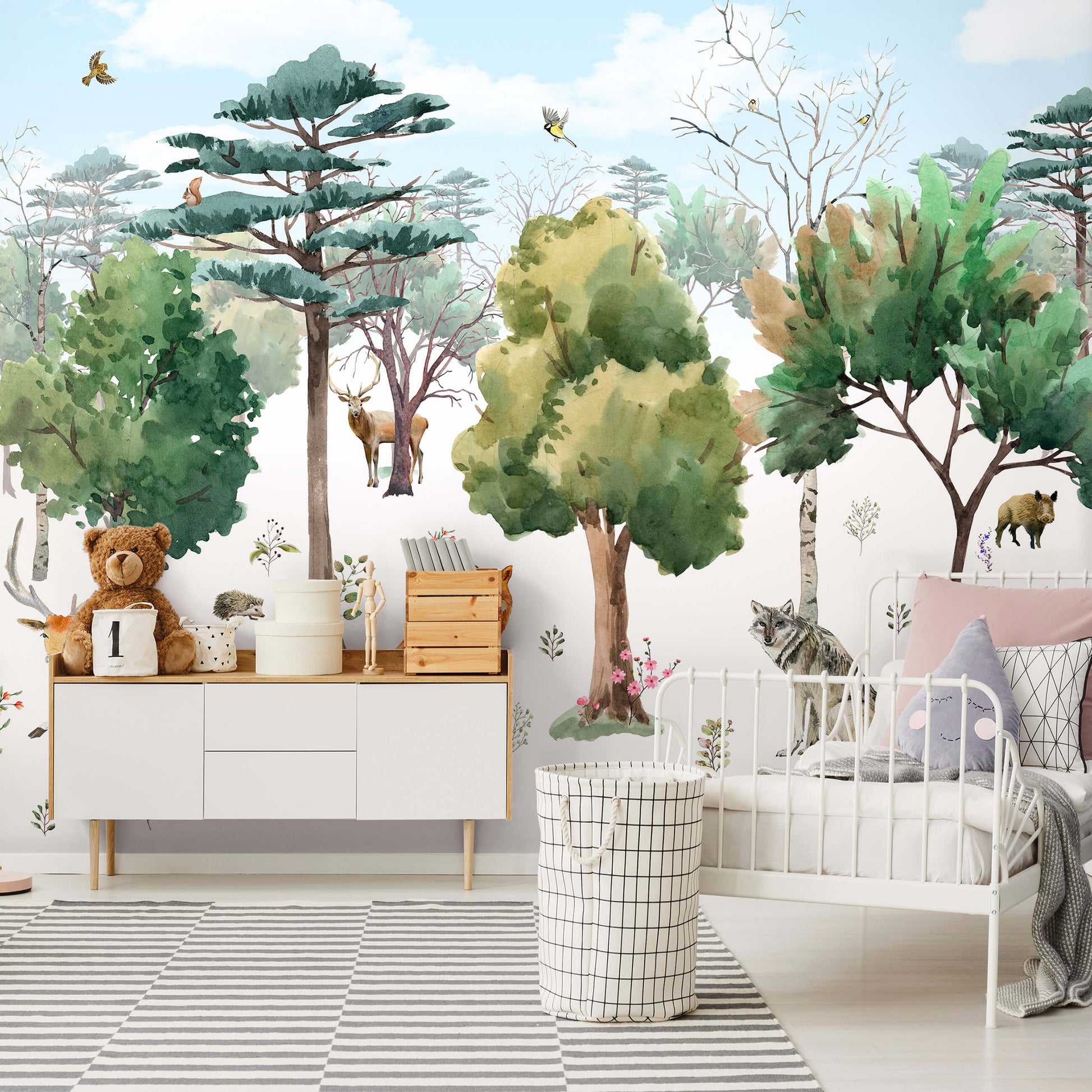 A section of wallpaper featuring a forest animal theme with a green tree, brown bear, and various decorative elements applied on a wall in a room setting.