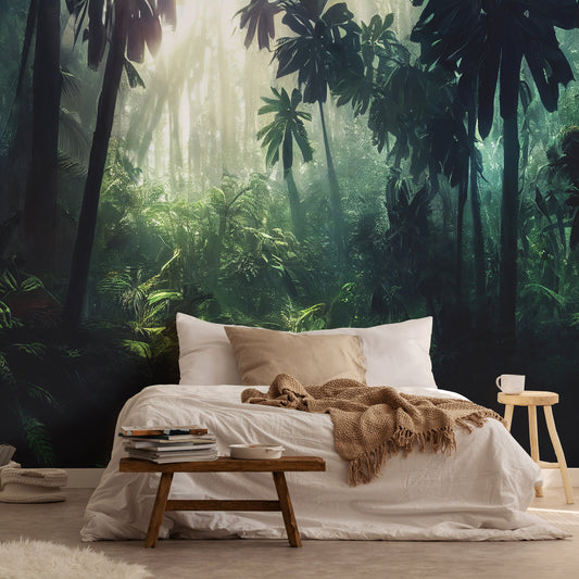 A bedroom with a jungle-themed non-woven photo wallpaper featuring a lush rainforest background. The bed is placed against a wall with a large window, and there is a wooden side table with a cup and a book on the bed.