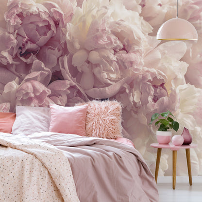 Bedroom with floral wallpaper, pink bedding, and a small table with a plant.
