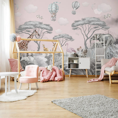 Children's room with pink wall, animal-themed wallpaper, and wooden playhouse.