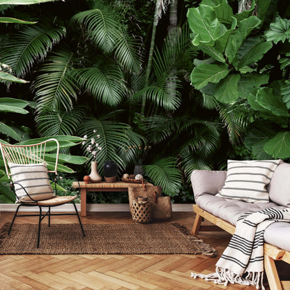Tropical-themed indoor setting with a couch, chair, and decorative items against a lush green leafy background.