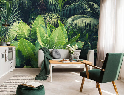 Living room with tropical leaf wallpaper, white sofa, and green armchair.