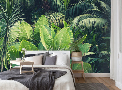 Bedroom with a tropical leaf wallpaper featuring a large bed and side tables.