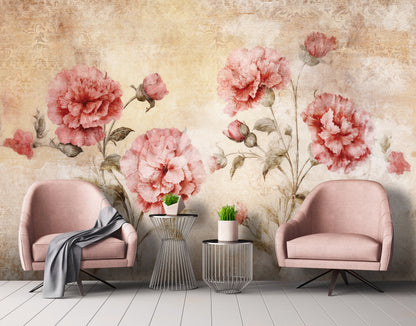 Two pink chairs with a small table between them against a floral wallpapered wall.