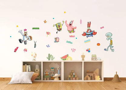 A children's room scene with SpongeBob-themed wall decals displayed on a light beige wall above a low wooden shelf with toys and books.